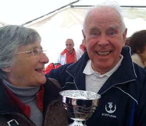 Sue Cassell admires the cup awarded for fifth place, held by President George Black